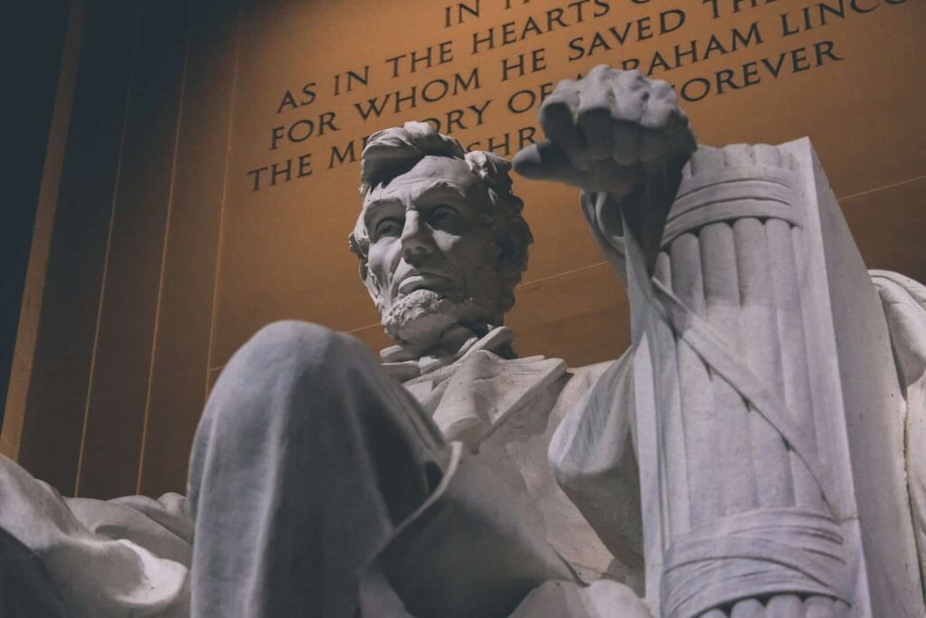 man in white robe holding a book statue