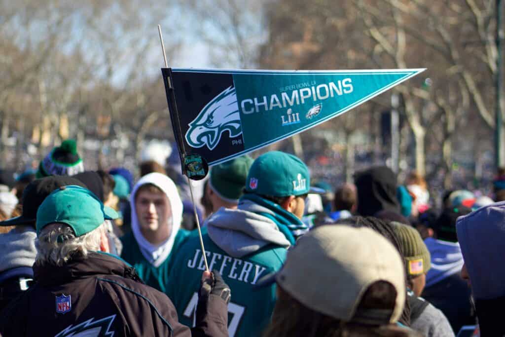 man holding Philadelphia Eagle pennant