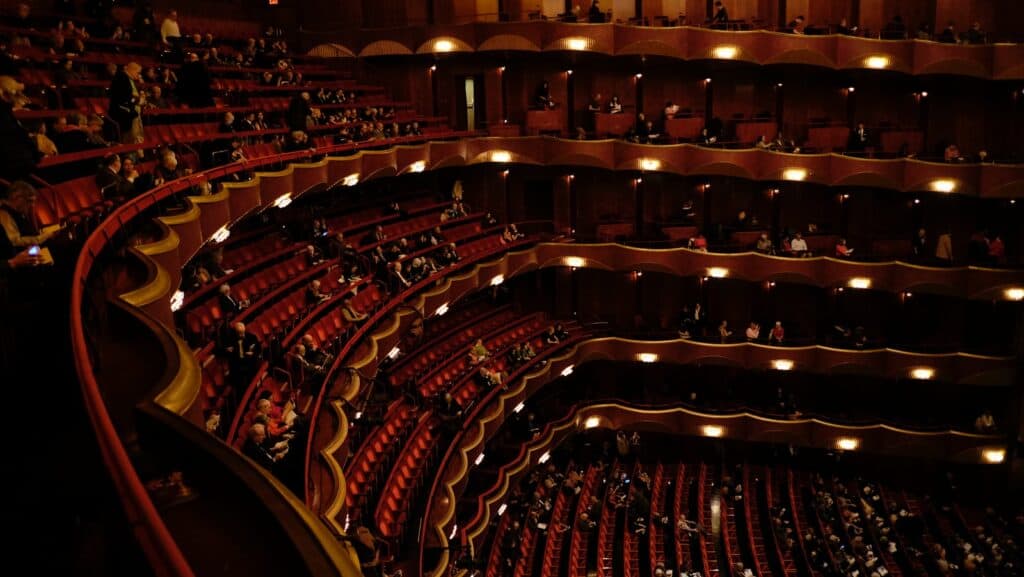 photography of people sitting on theater during nighttime