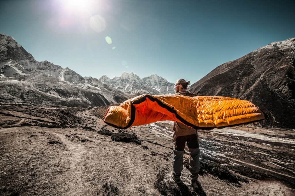 man standing on field between cliffs